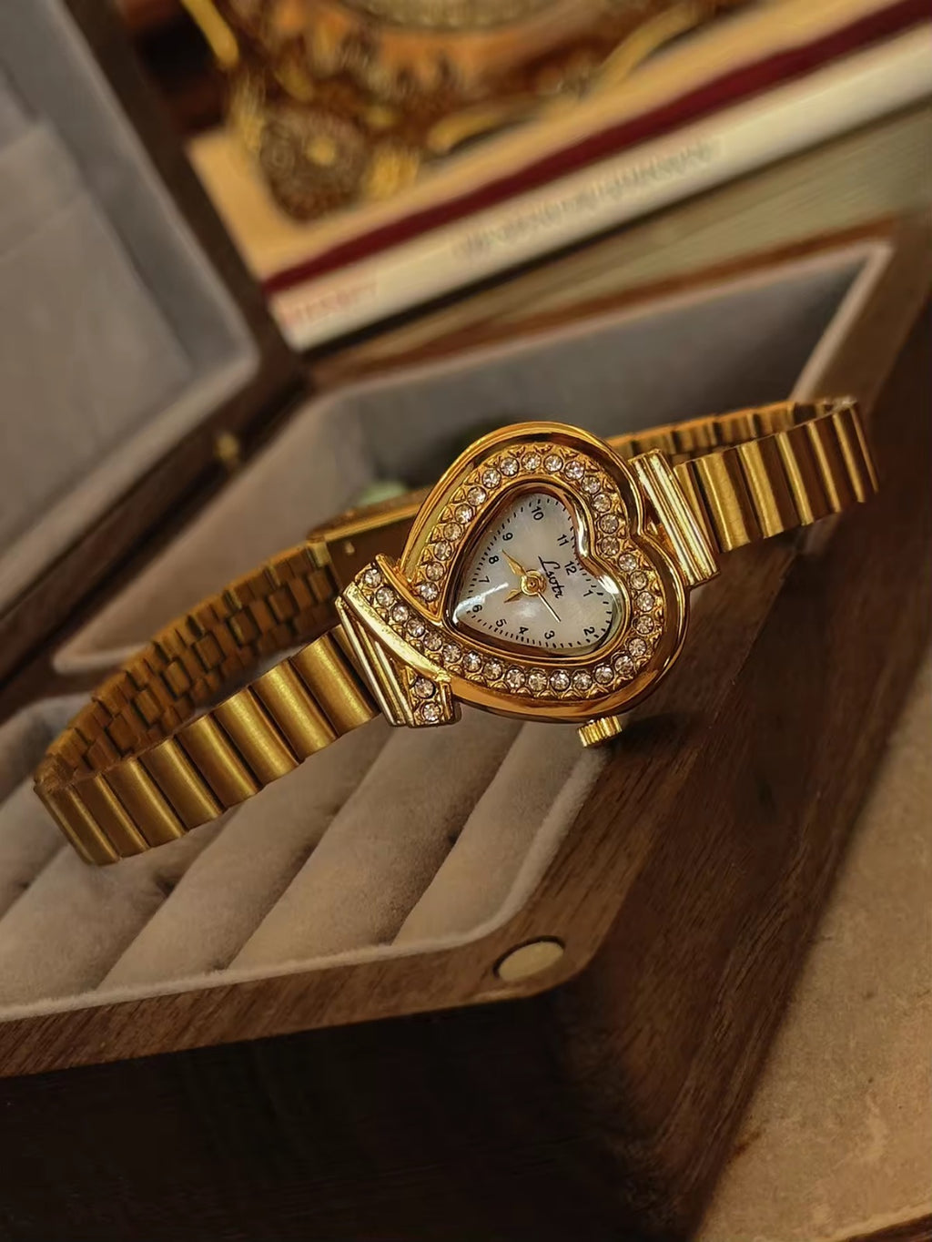 Gold heart-shaped quartz watch with double pav´e crystal halo bezel,
white dial, crossed bow lugs and wide ribbed gold flex bracelet for women by Le Belle Heure