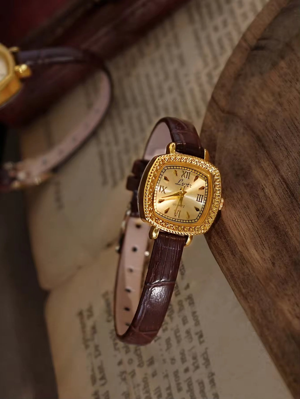 Gold cushion square watch with rope-twist crystal bezel, sunburst
Roman numeral champagne dial and slim dark chocolate crocodile texture leather strap for women by Le Belle Heure