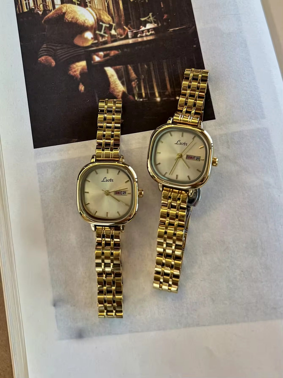 Gold square couple watch set with champagne dial and day-date display on gold stainless steel bracelet - Le Belle Heure