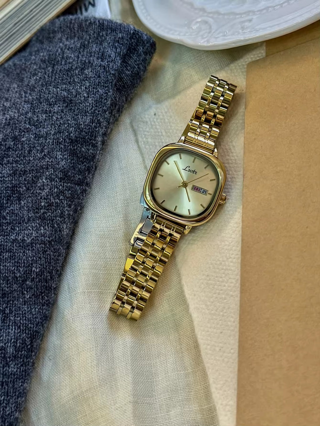 Gold square couple watch set with champagne dial and day-date display on gold stainless steel bracelet - Le Belle Heure