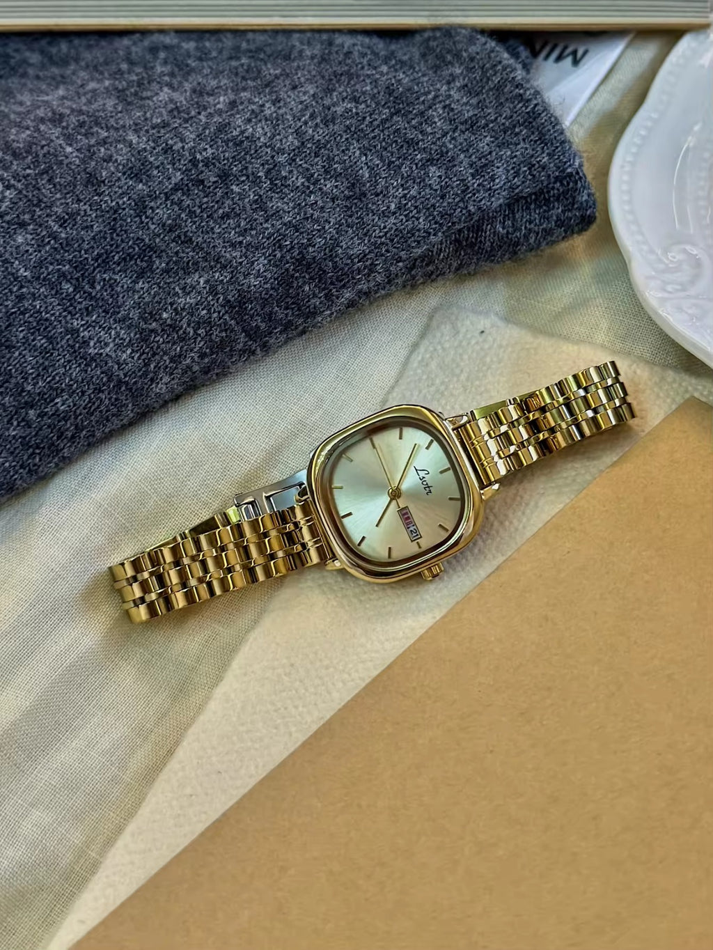 Gold square couple watch set with champagne dial and day-date display on gold stainless steel bracelet - Le Belle Heure